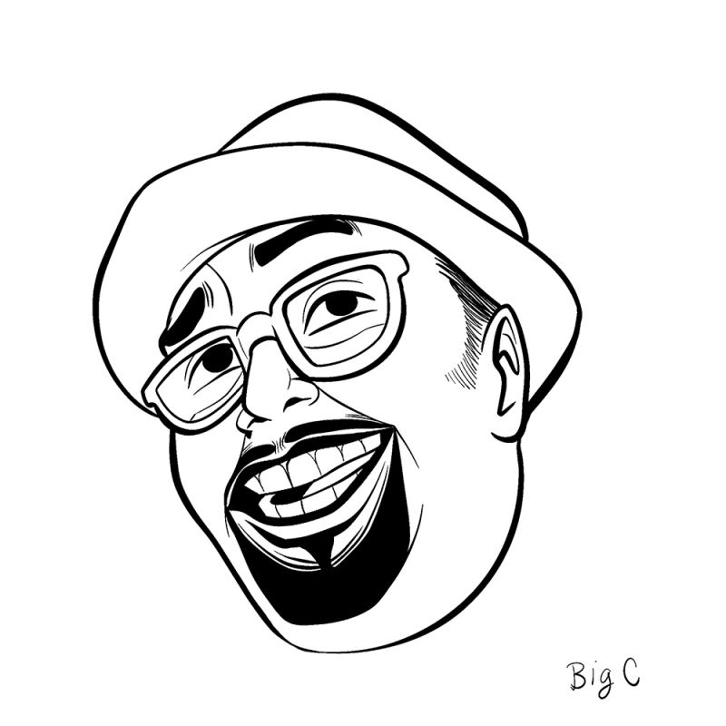 A smiling man with a goatee and black rimmed glasses wearing a short brim hat.