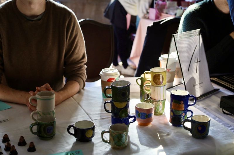 Student vendors sell their clay crafts at the art market. 