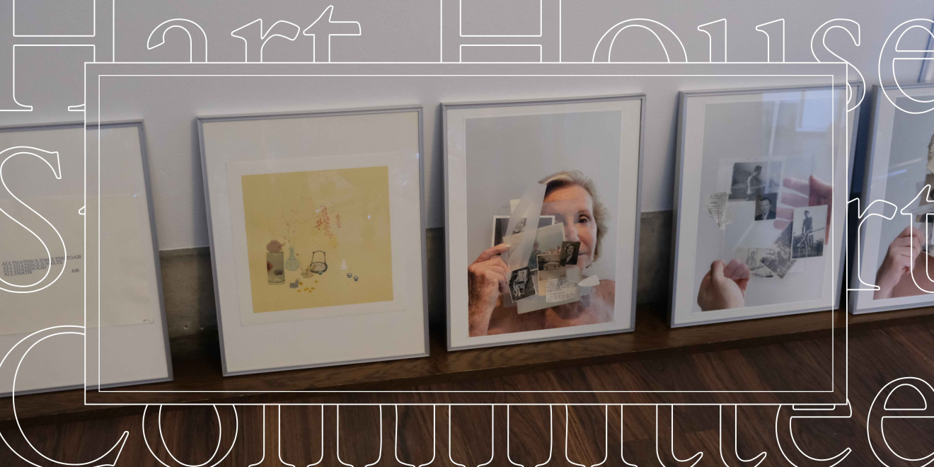 A series of framed colour photographs placed on the floor and leaning against a wall. 