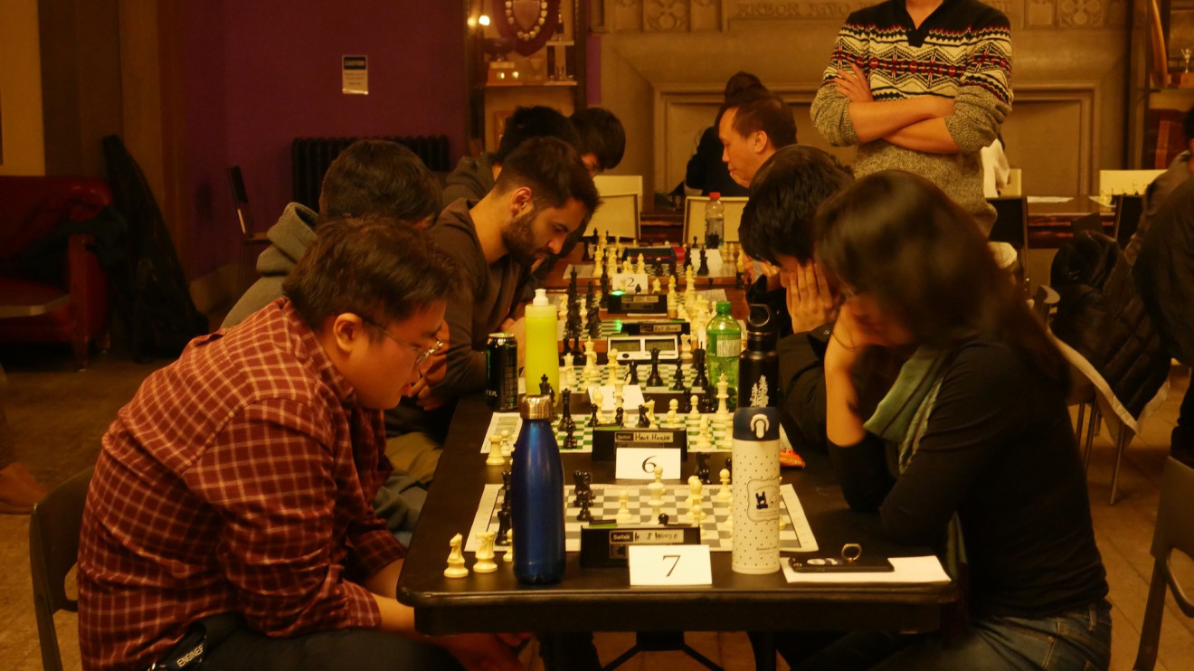 a photo of players in a chess tournament, mid-game.