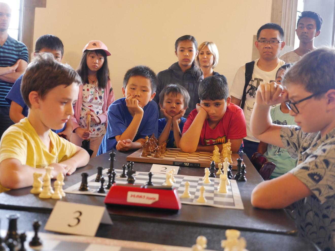 Image of children playing chess in a tournament setting.