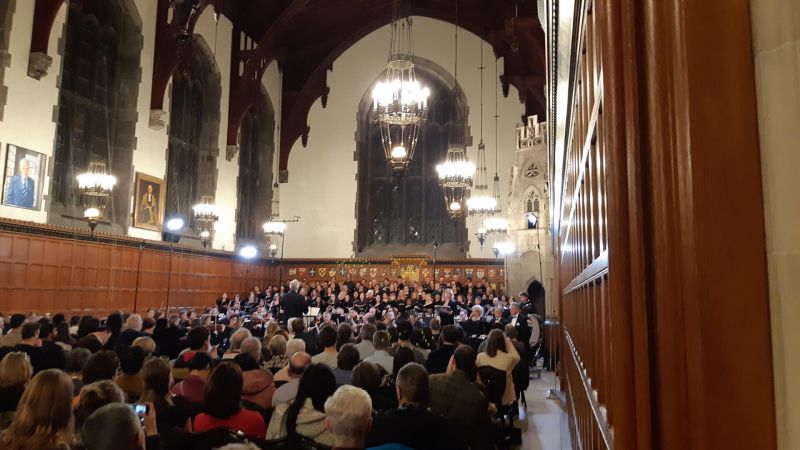 A great hall full of audiences listening to a live singer's concert 