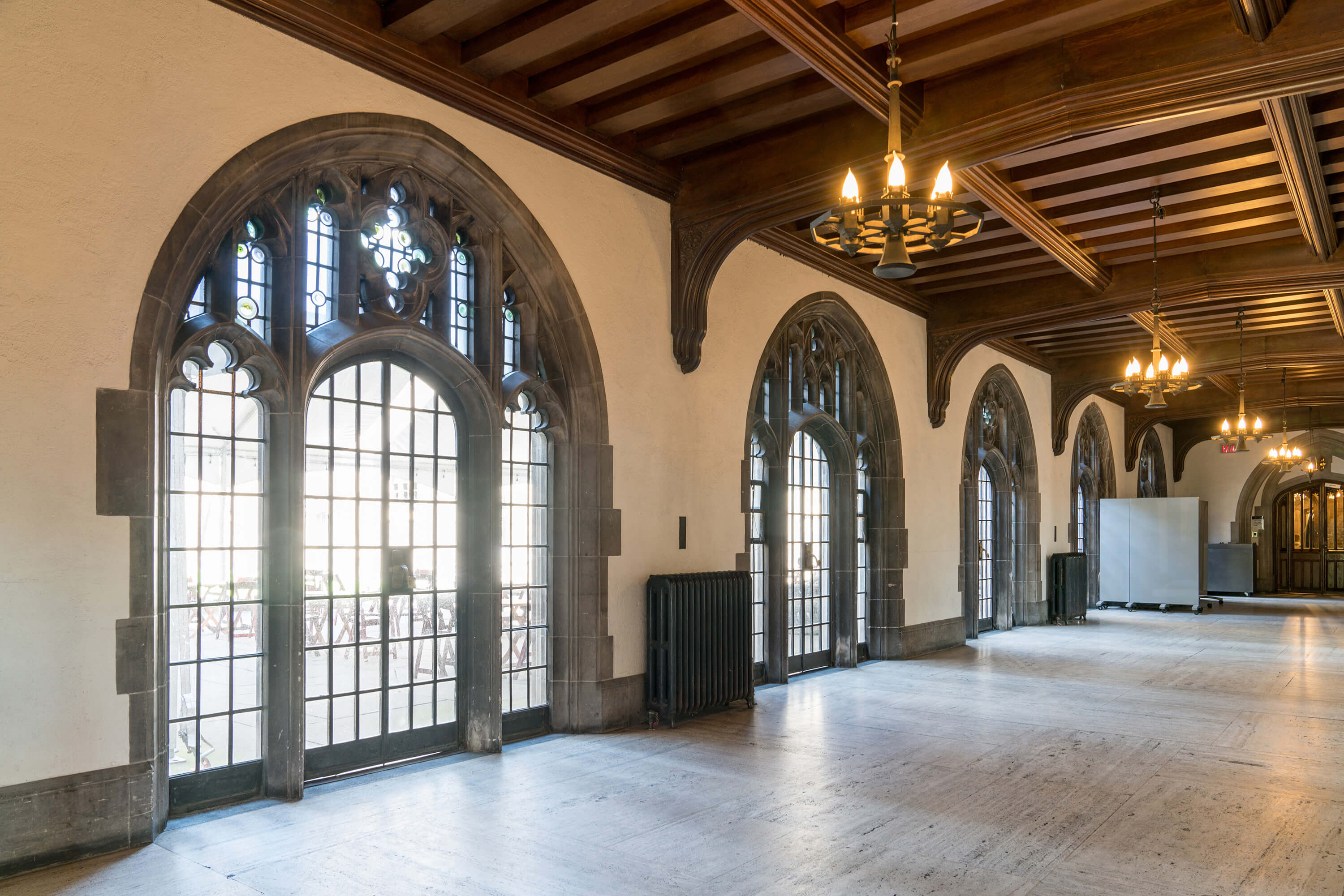 A broad hallway with arched windows and doors