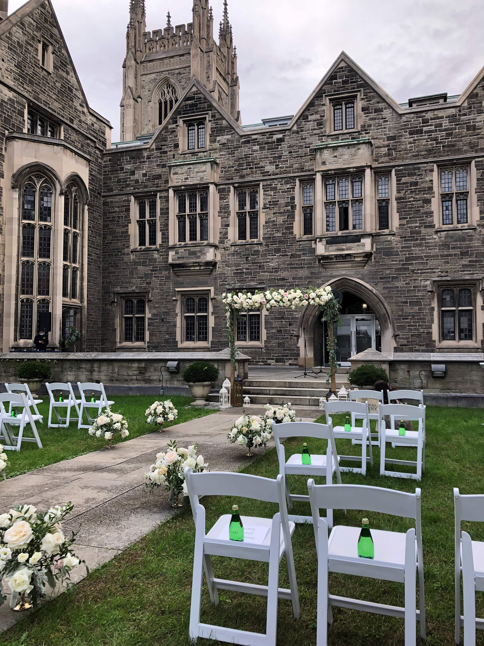 The Hart House Quad and greenery in the sunshine, with seating arranged for a ceremony